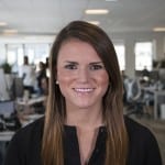 Headshot of a woman with an office in the background