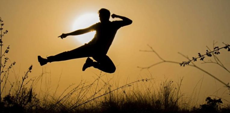 Silhouette of a person in midair in a fight pose