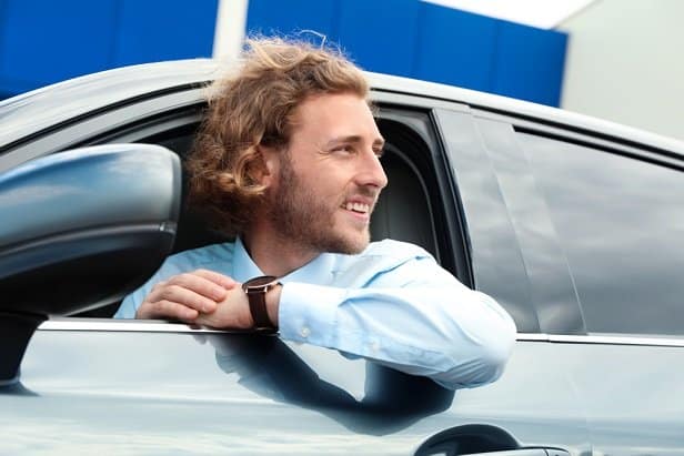 Man with his head coming out of an open car window