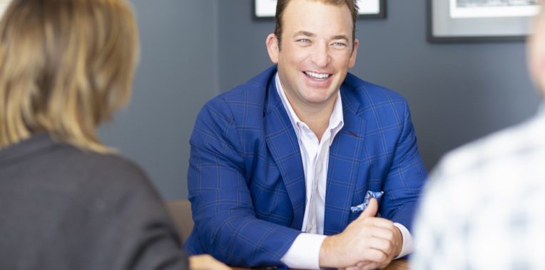 Laughing man facing two other people