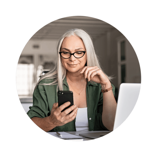 Woman in glasses looking down at a cell phone screen