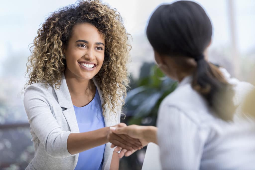Woman shaking another person's hand