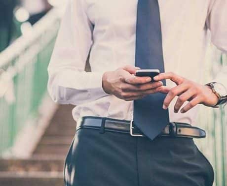 A torso with hands holding a cell phone