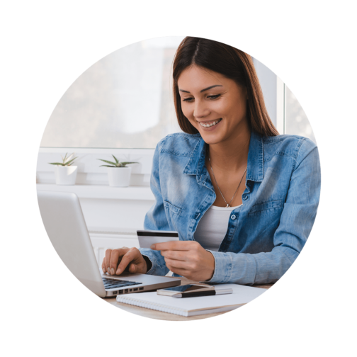 Woman with her hand on a laptop looking down at a credit card