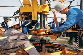 Two people working an oil drill