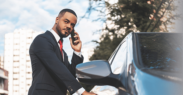 Man opening a car door while talking on a cell phone