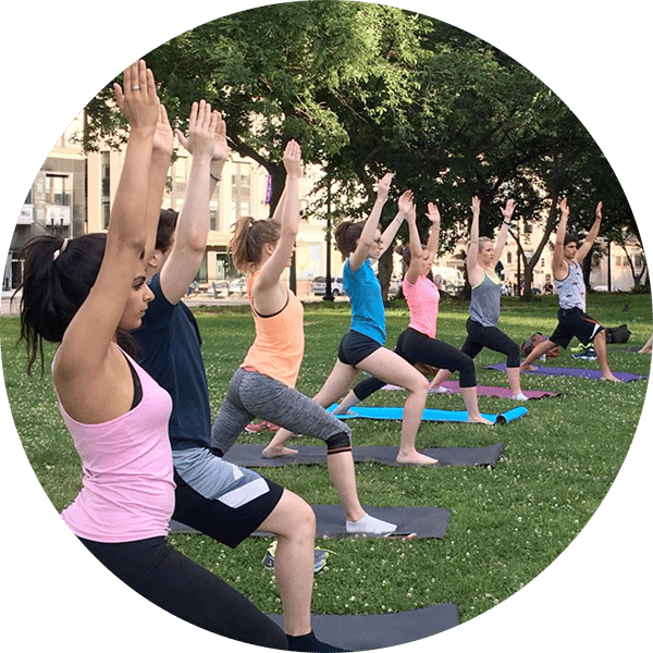 A line of people doing yoga in a park