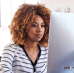 Woman in a striped shirt looking at a computer screen