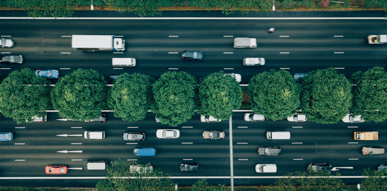 overhead shot of vehicles driving on multi lane street evoking environmental compliance