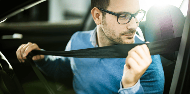 image of man buckling seatbelt, evoking driver compliance