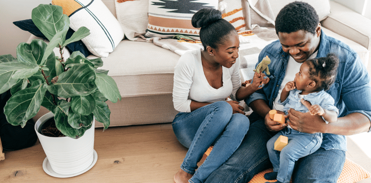 young couple playing with toddler evoking Motus and Maven