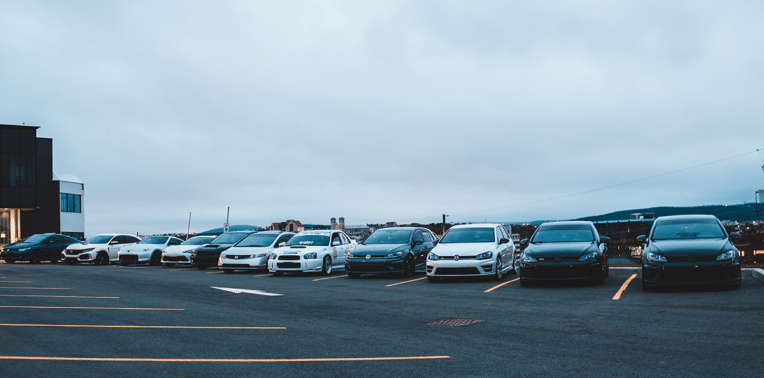 row of cars in a parking lot evoking fleet vehicle mileage reporting