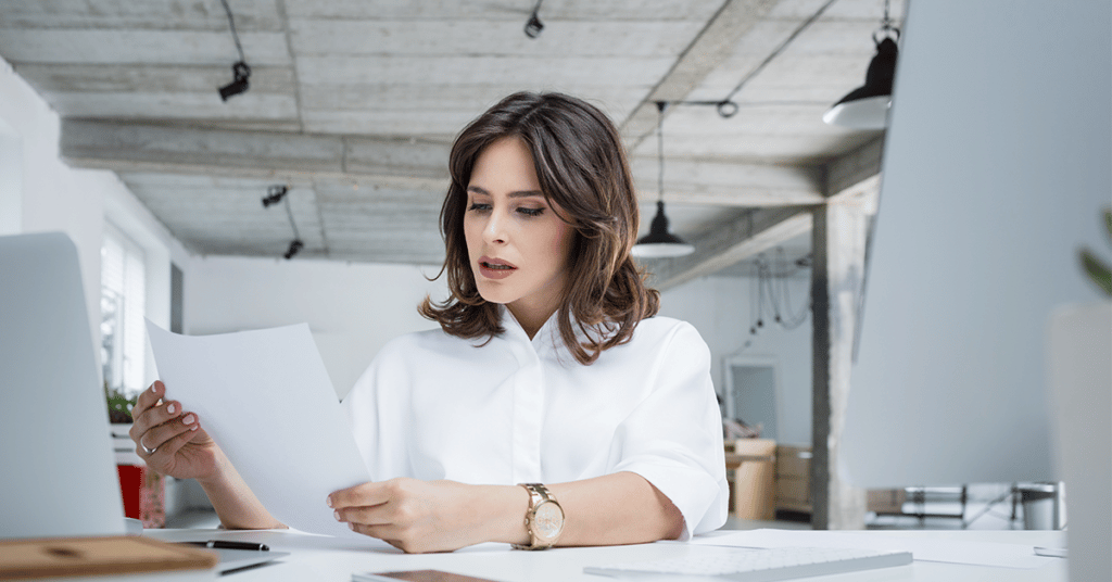 image of concerned business person at desk holding paperwork evoking mileage fraud