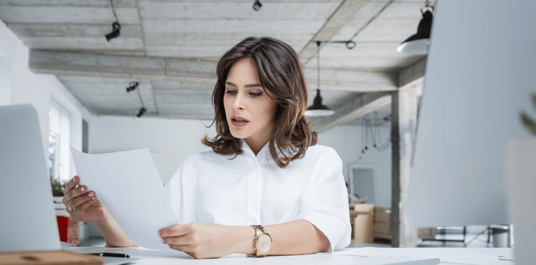 image of concerned business person at desk holding paperwork evoking mileage fraud