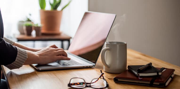 person using desk at home evoking benefits of telecommuting