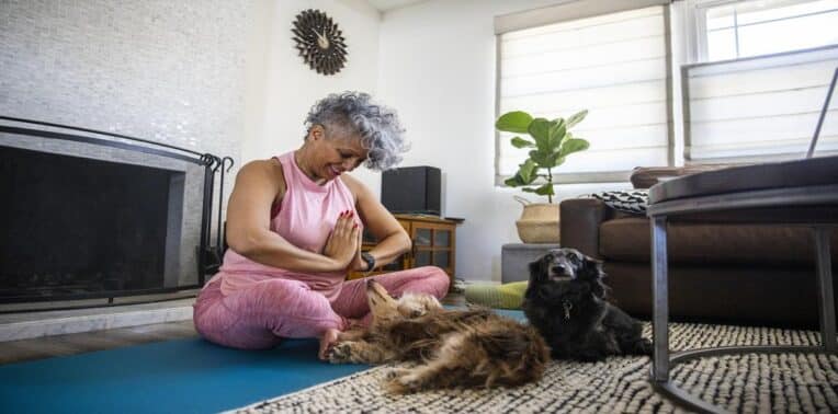 woman doing yoga with puppies evoking modern health