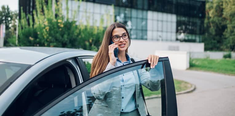 business woman on her phone leaving her vehicle evoking Personal Asset Reimbursement