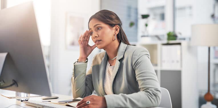 business woman overwhelmed at computer, evoking change management