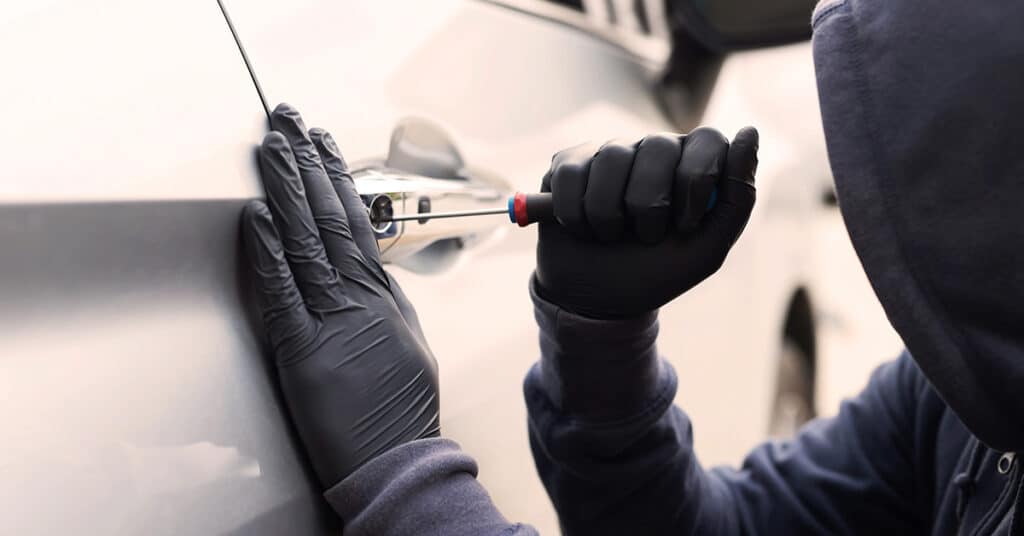 thief breaking into car evoking vehicle theft prevention