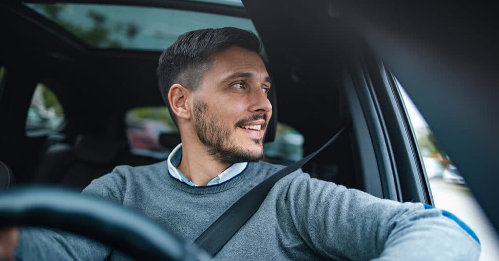 man in driver's seat of vehicle evoking FAVR vs mileage reimbursement